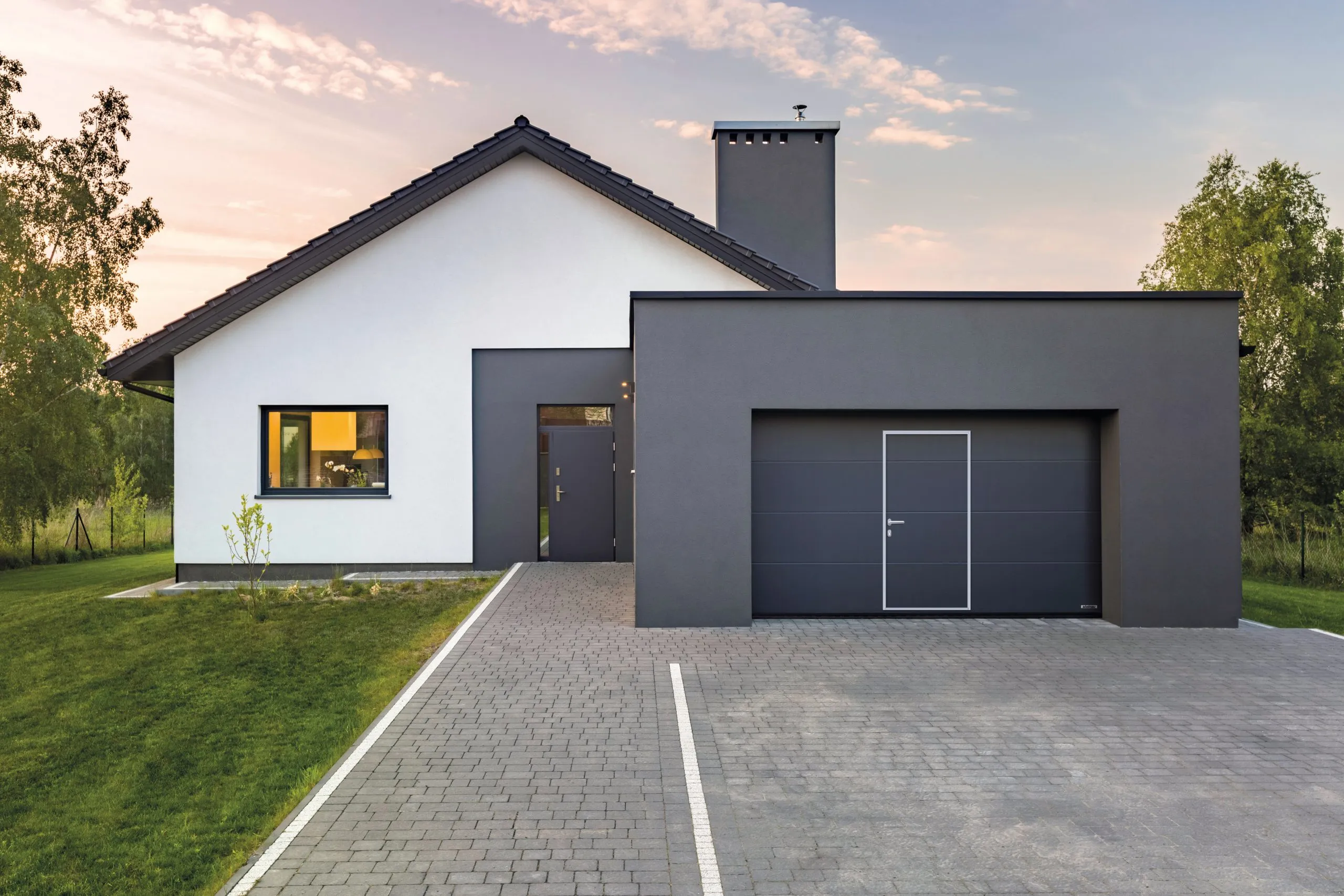 Modernes Haus mit Garage und gruenem Rasen
